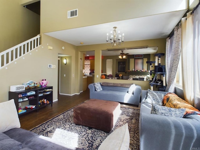 living room featuring ceiling fan with notable chandelier and dark hardwood / wood-style flooring