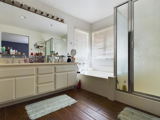 bathroom with hardwood / wood-style flooring, vanity, and shower with separate bathtub