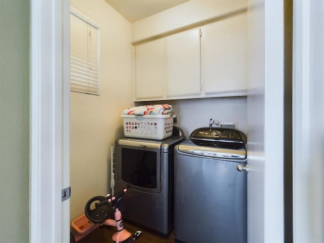 washroom with cabinets and washing machine and clothes dryer