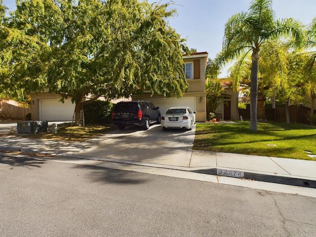 view of property hidden behind natural elements with a garage and a front lawn