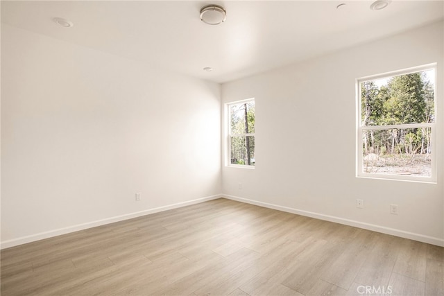 unfurnished room featuring light hardwood / wood-style flooring and plenty of natural light