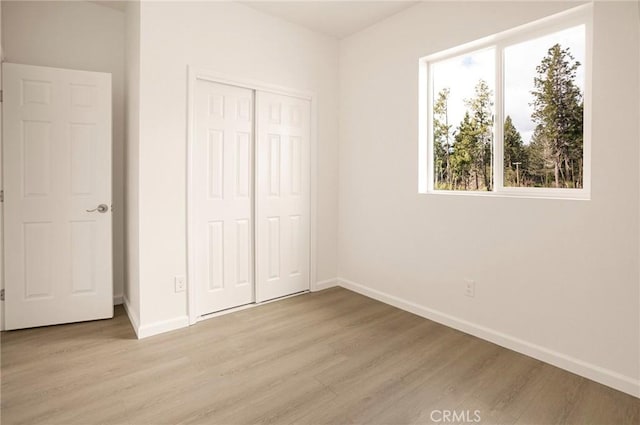 13990 Pineland Cir, Magalia, CA 95954 - unfurnished bedroom featuring light wood-style floors, baseboards, and a closet