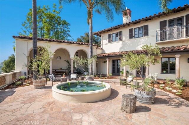 rear view of house featuring a patio area and a balcony