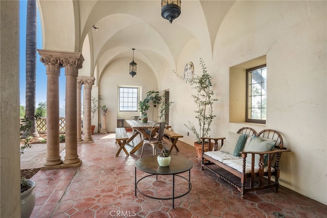 sitting room featuring lofted ceiling and decorative columns