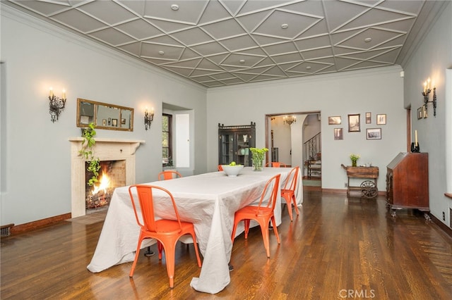 dining space with ornamental molding and dark hardwood / wood-style flooring