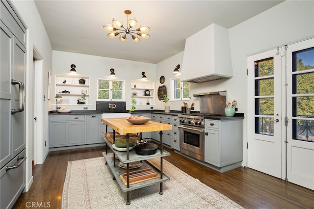 kitchen with an inviting chandelier, dark hardwood / wood-style floors, custom range hood, gray cabinets, and high end range