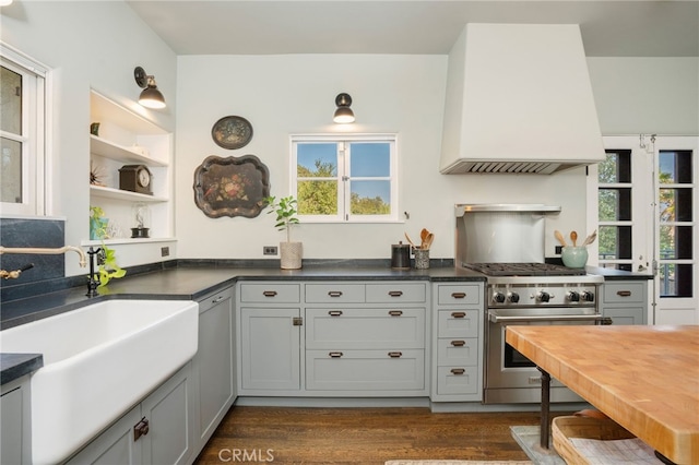 kitchen with high end range, custom range hood, dark hardwood / wood-style floors, and gray cabinets