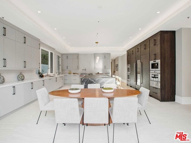 dining space featuring sink and a tray ceiling