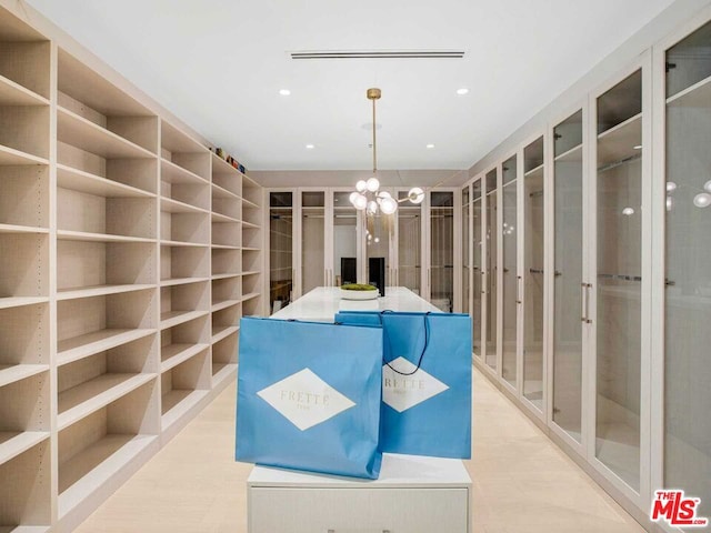 spacious closet featuring an inviting chandelier