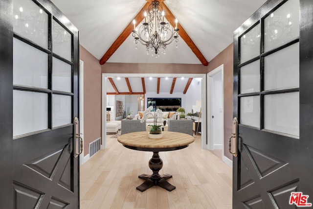 entrance foyer with vaulted ceiling with beams, light hardwood / wood-style floors, and an inviting chandelier