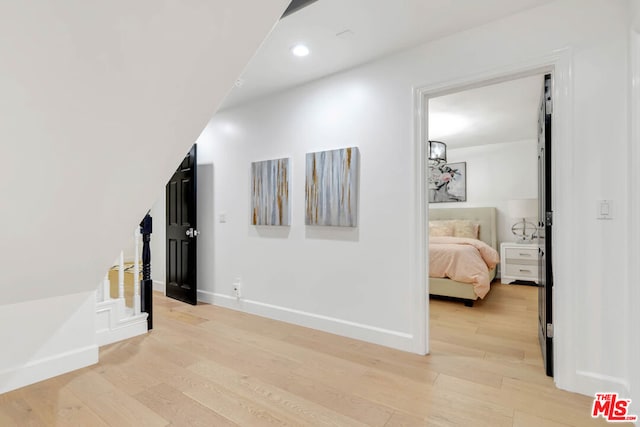 hallway with light hardwood / wood-style floors