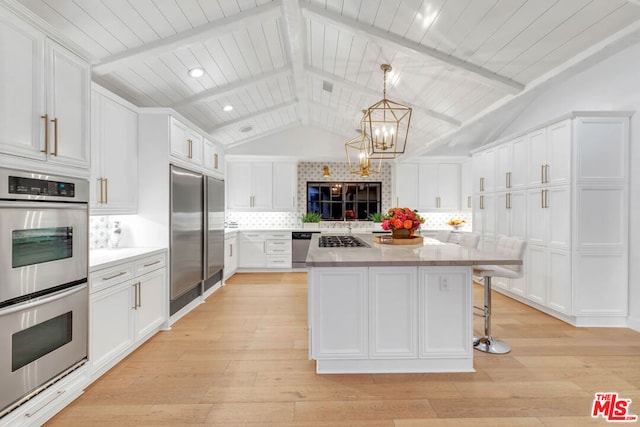 kitchen featuring appliances with stainless steel finishes, lofted ceiling with beams, white cabinetry, and light hardwood / wood-style flooring