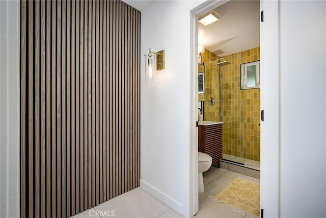 bathroom featuring a tile shower, tile patterned flooring, and toilet