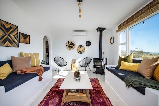 tiled living room featuring a wall mounted air conditioner and a wood stove