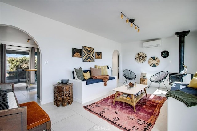 living room with track lighting, an AC wall unit, and light tile patterned flooring