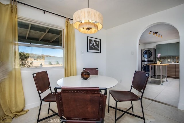 dining room featuring stacked washer / dryer