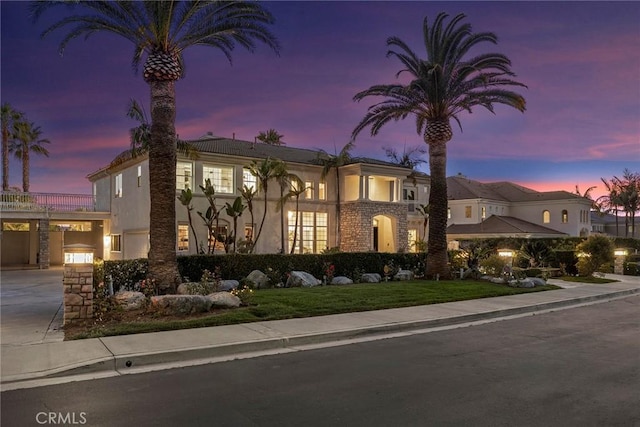 view of front of home featuring driveway, a yard, and stucco siding