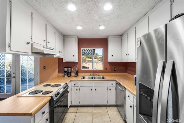 kitchen with white cabinets, stainless steel appliances, sink, and light tile patterned floors