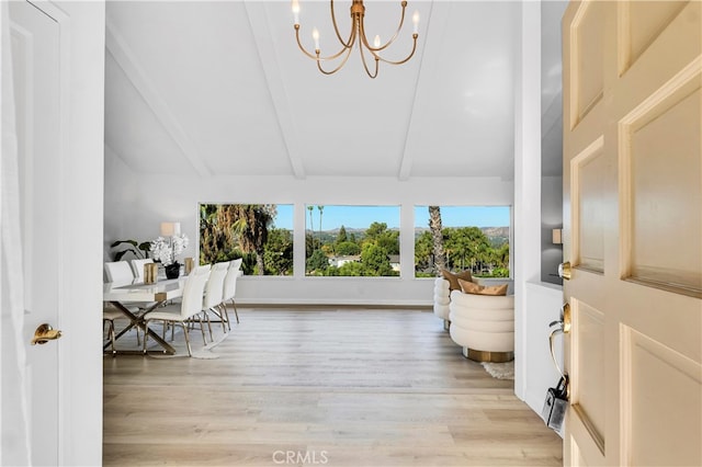 interior space featuring beam ceiling, light hardwood / wood-style flooring, and a chandelier