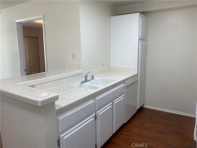 kitchen with white dishwasher, sink, dark hardwood / wood-style floors, tile counters, and kitchen peninsula