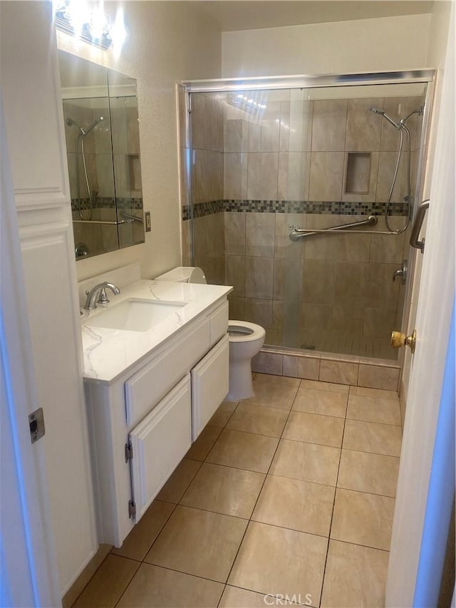 bathroom with tile patterned flooring, vanity, toilet, and an enclosed shower