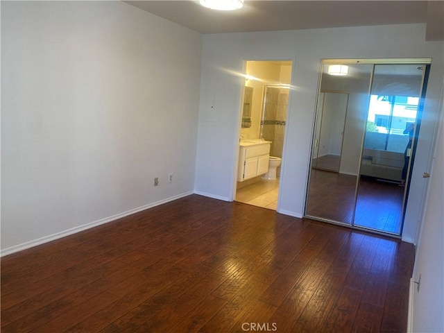 unfurnished bedroom featuring wood-type flooring and a closet