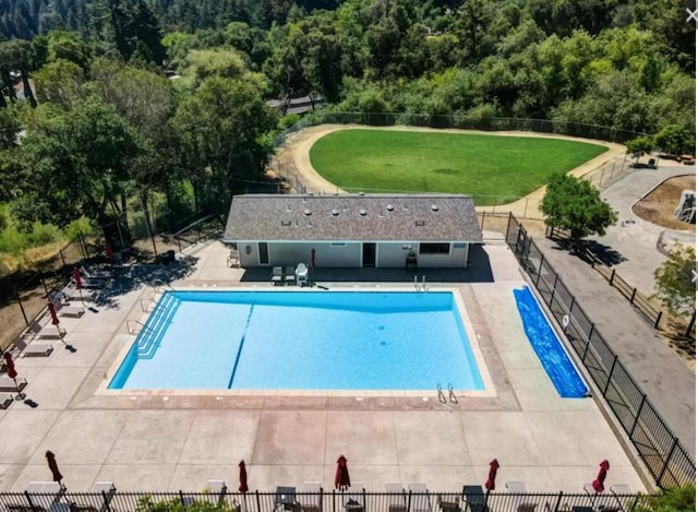 view of pool with a patio area and a lawn