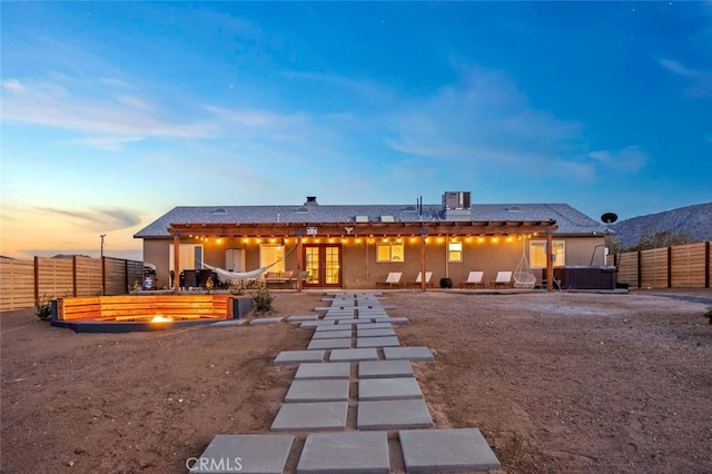 back house at dusk featuring a patio area and french doors