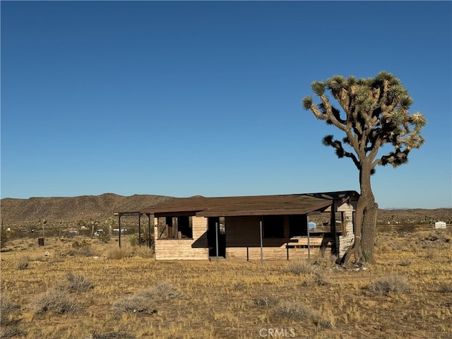 view of front of property featuring a mountain view and a rural view