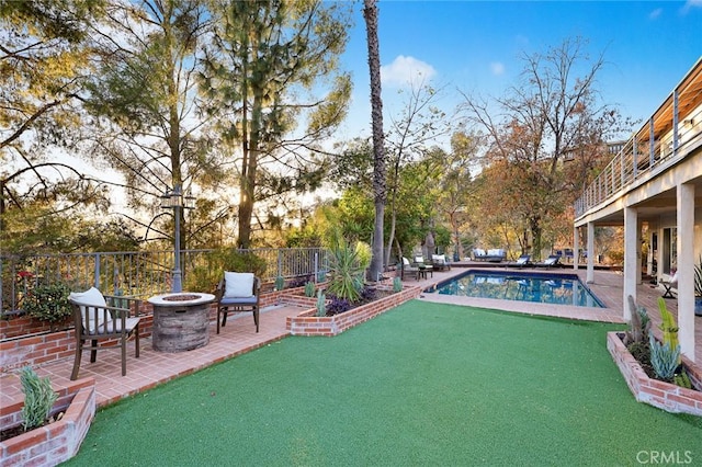 pool at dusk featuring a fire pit and a patio area