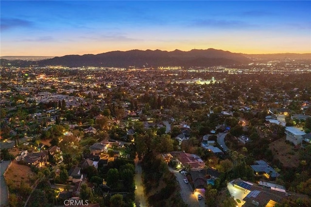 aerial view at dusk featuring a mountain view