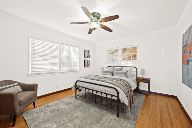 bedroom with ceiling fan, wood-type flooring, and ornamental molding