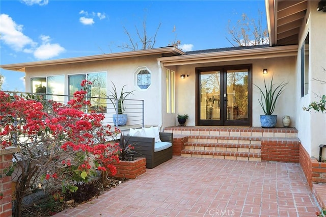 entrance to property featuring french doors and a patio area