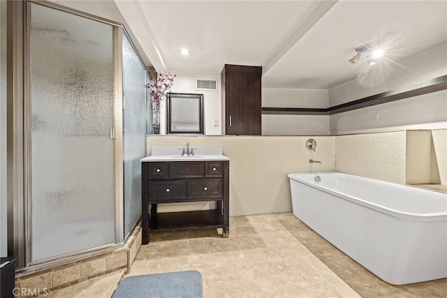 bathroom featuring tile patterned floors, vanity, and shower with separate bathtub