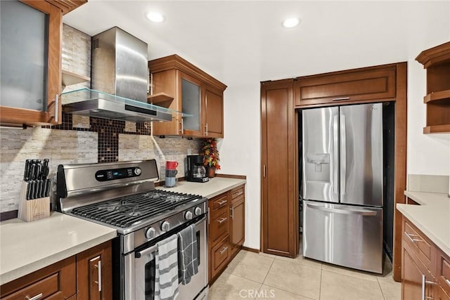 kitchen with tasteful backsplash, light tile patterned flooring, stainless steel appliances, and wall chimney range hood