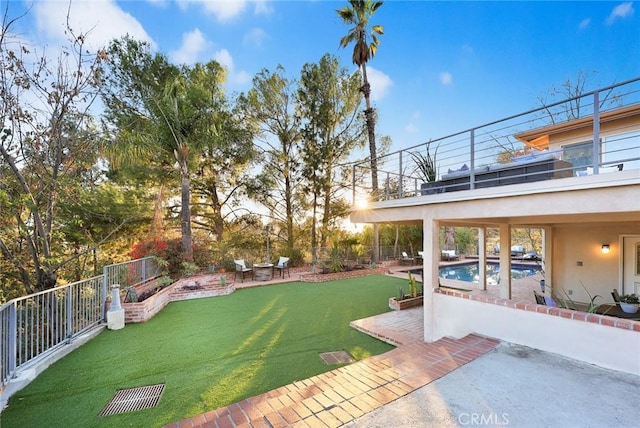 view of yard with a patio area, a fenced in pool, and a balcony