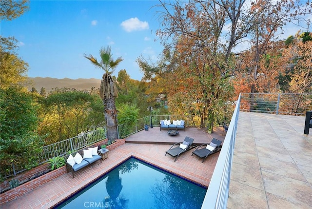 view of swimming pool with a patio area, a mountain view, and an outdoor hangout area