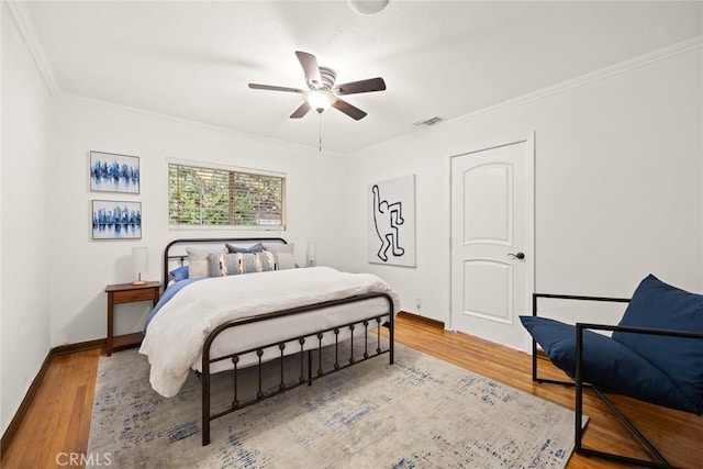 bedroom with ceiling fan, wood-type flooring, and ornamental molding