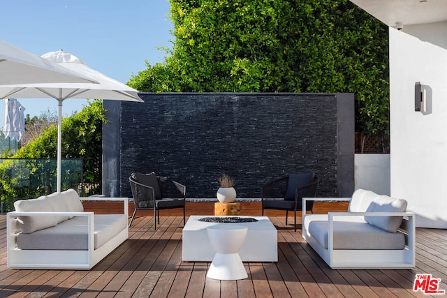 wooden terrace featuring an outdoor living space with a fire pit