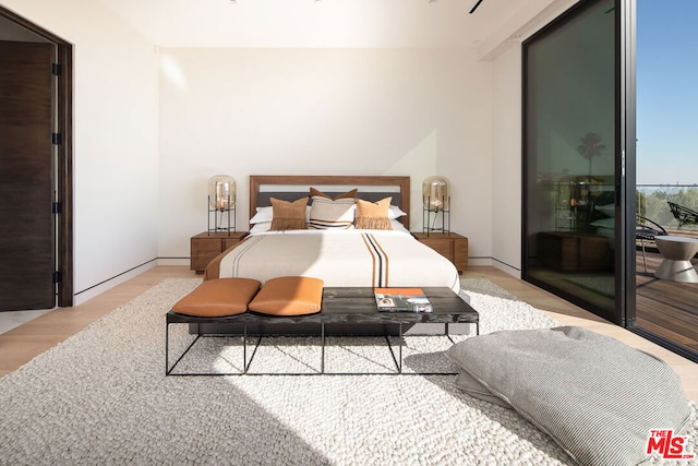 bedroom featuring light wood-type flooring and access to outside