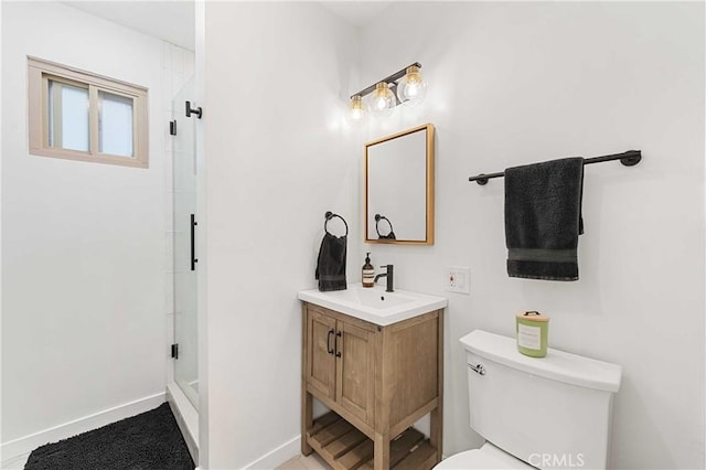 bathroom featuring vanity, toilet, and a shower with door