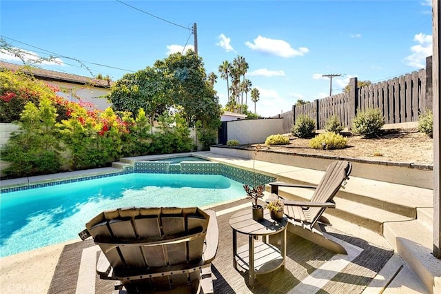 view of swimming pool featuring an in ground hot tub