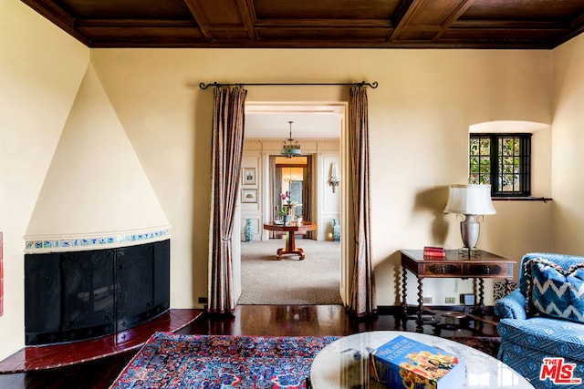 living room featuring coffered ceiling, wooden ceiling, dark hardwood / wood-style flooring, and ornamental molding