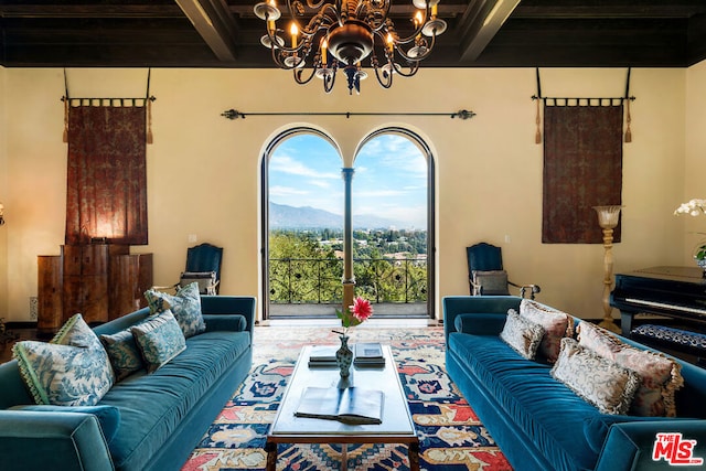 living room featuring beam ceiling, wooden ceiling, a mountain view, and a chandelier