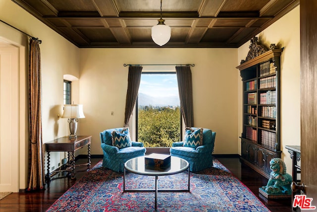 sitting room featuring coffered ceiling and dark hardwood / wood-style flooring