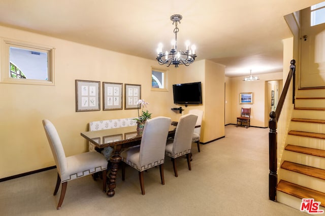 dining space with a chandelier and light colored carpet