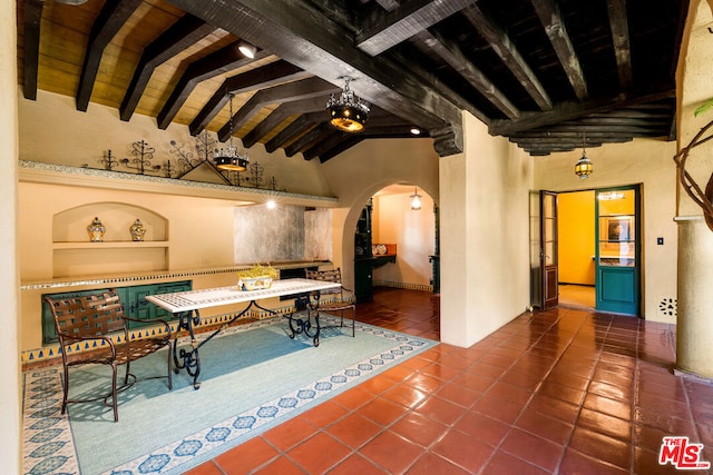 interior space with lofted ceiling with beams and tile patterned floors