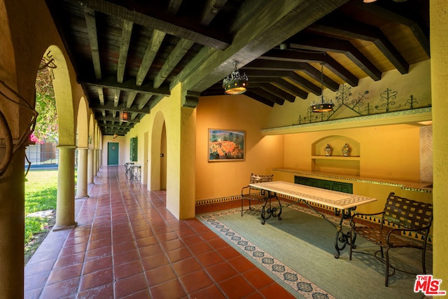 playroom with lofted ceiling with beams and dark tile patterned floors