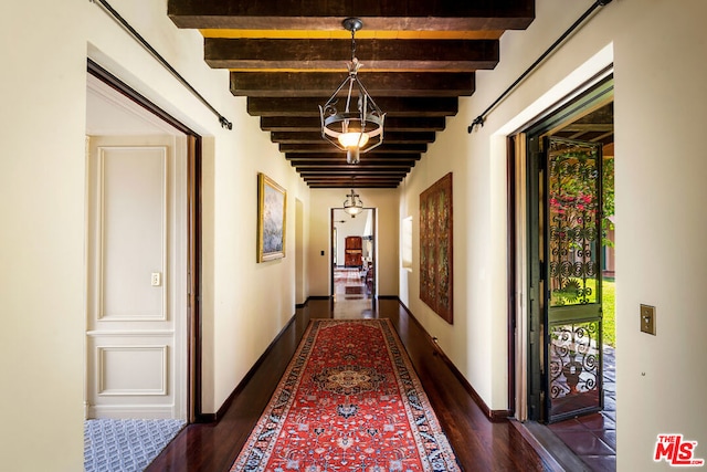 hall with dark wood-type flooring and beamed ceiling