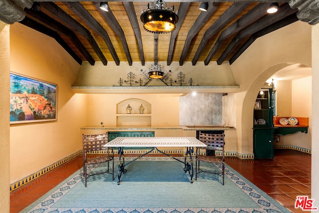 misc room with lofted ceiling with beams and dark tile patterned floors